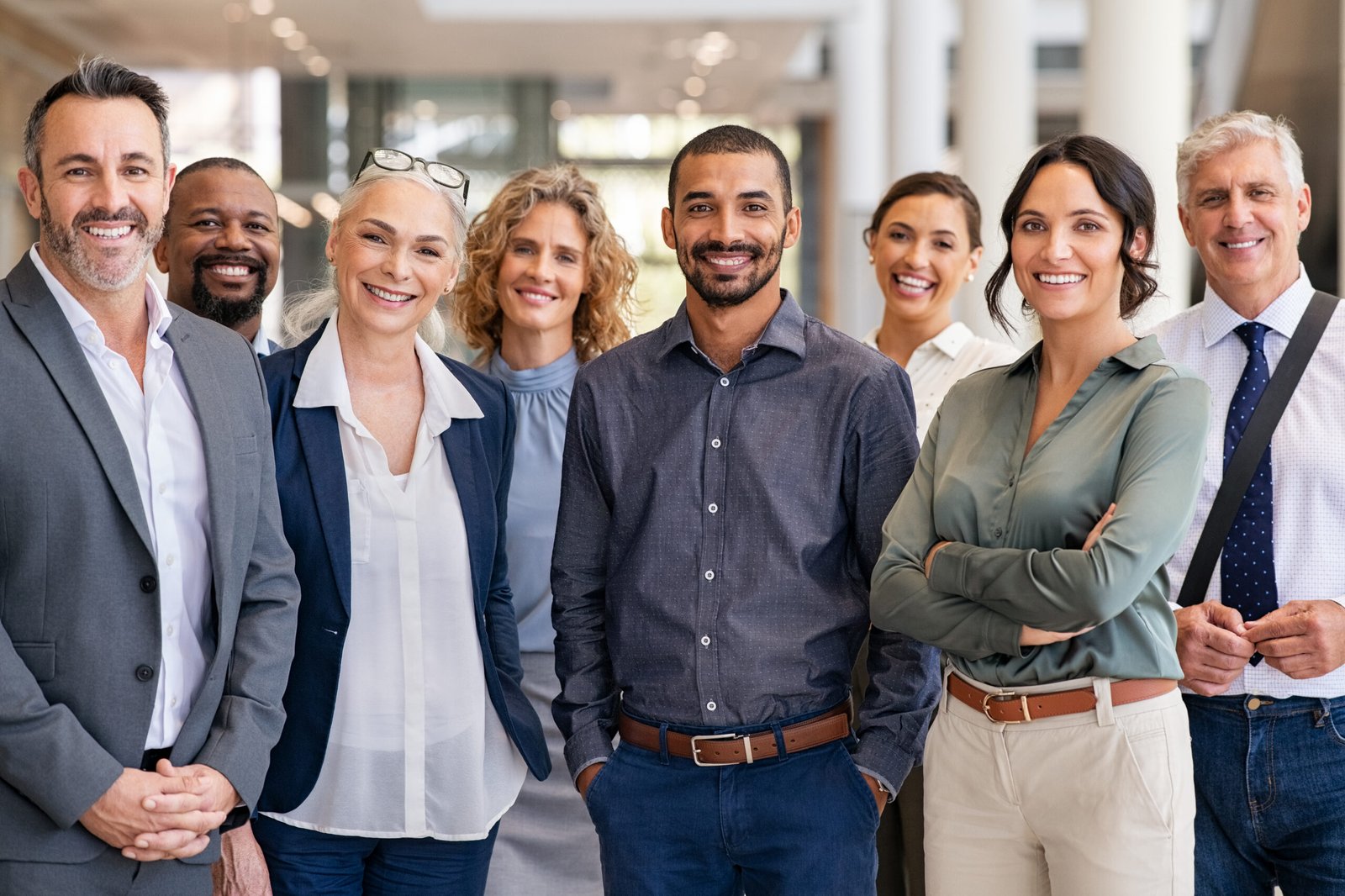 Group of successful multiethnic business team Portrait of successful group of business people at modern office looking at camera. Portrait of happy businessmen and satisfied businesswomen standing as a team. Multiethnic group of people smiling and looking at camera.